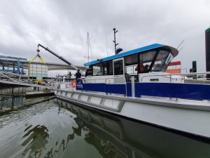 work boat lifting a container with onboard crane