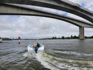 boat tender going under a bridge
