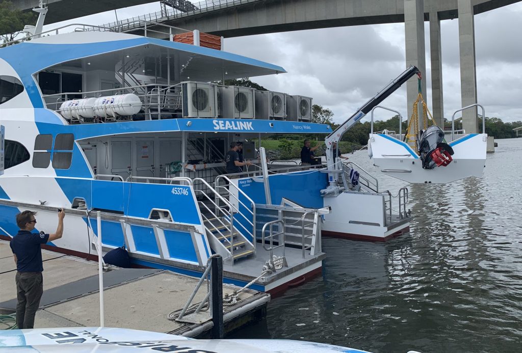 ferry with crane lifting tender